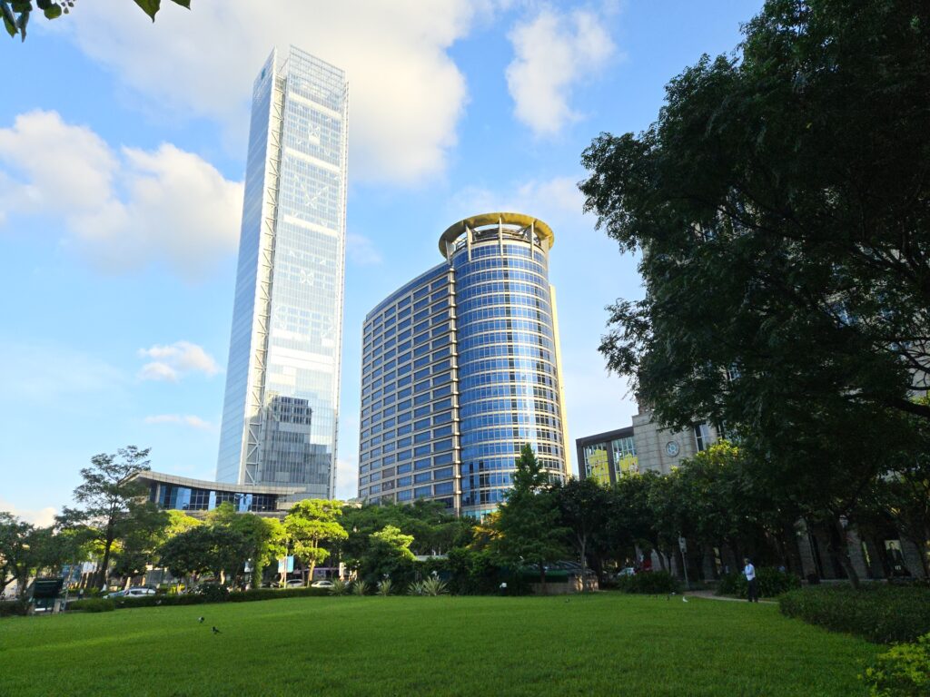 Taipei XinYi DistrictTaipei City Hall Station Golden Hour Walk Green space behind Taipei City Hall Station, nestled between Breeze Xinyi and Bellavita shopping centers, with a view of the China Petroleum Corporation building and Fubon Xinyi Tower.
